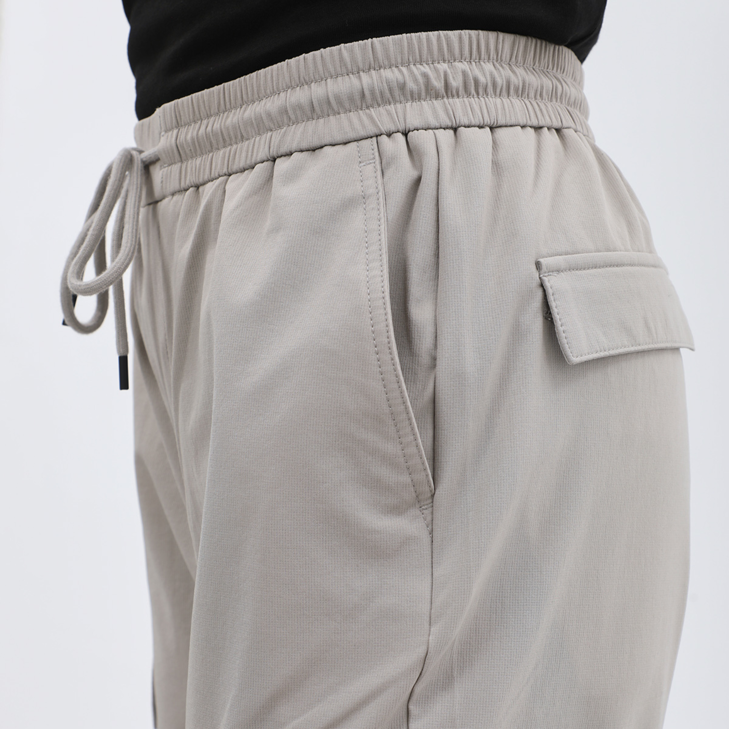Man wearing navy slim-fit cargo pants with side pockets and drawstring waist.